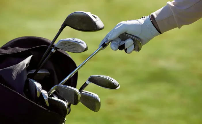 Gloved hand drawing a club from the bag