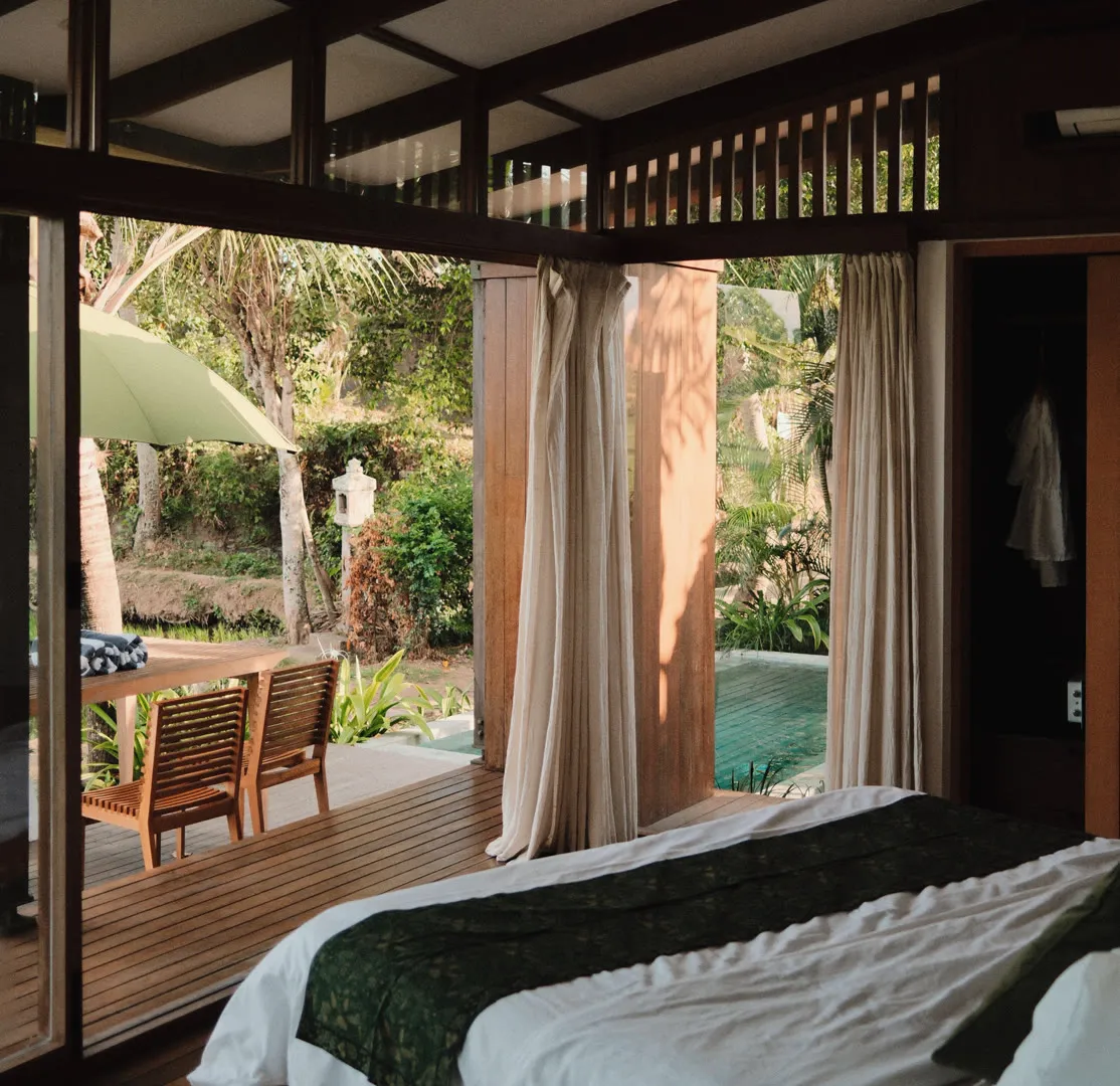 Bedroom opening onto a timber deck and garden