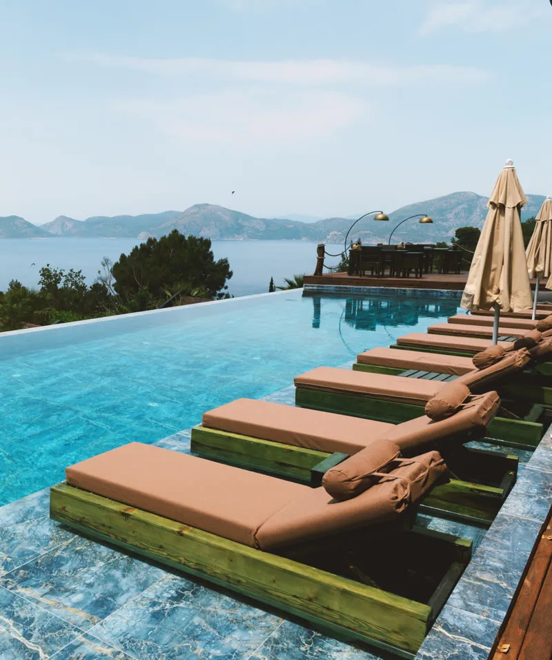 Infinity pool with loungers above the bay