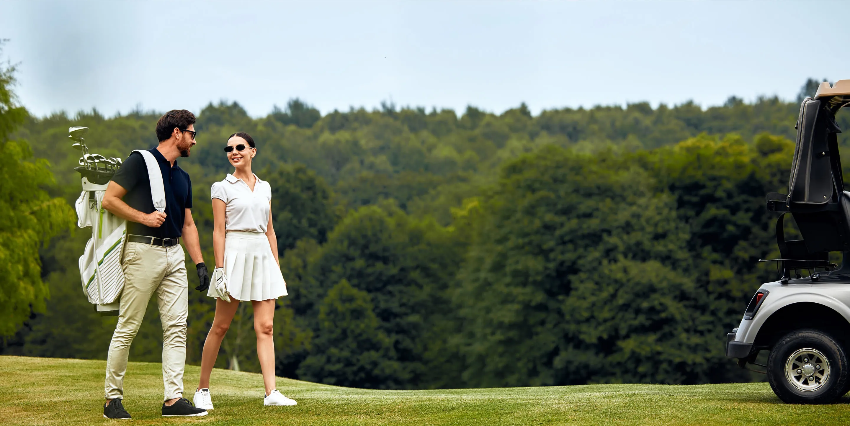 Couple walking the course with a golf bag