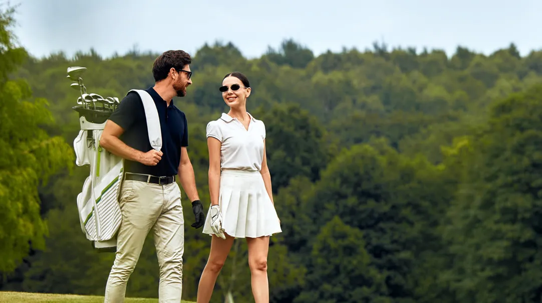 Couple walking the course with a golf bag