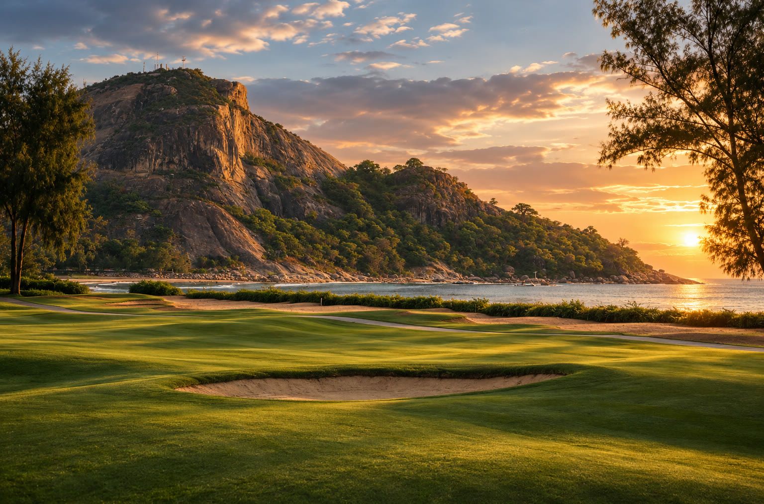 Sunset over a seaside fairway below a rocky headland