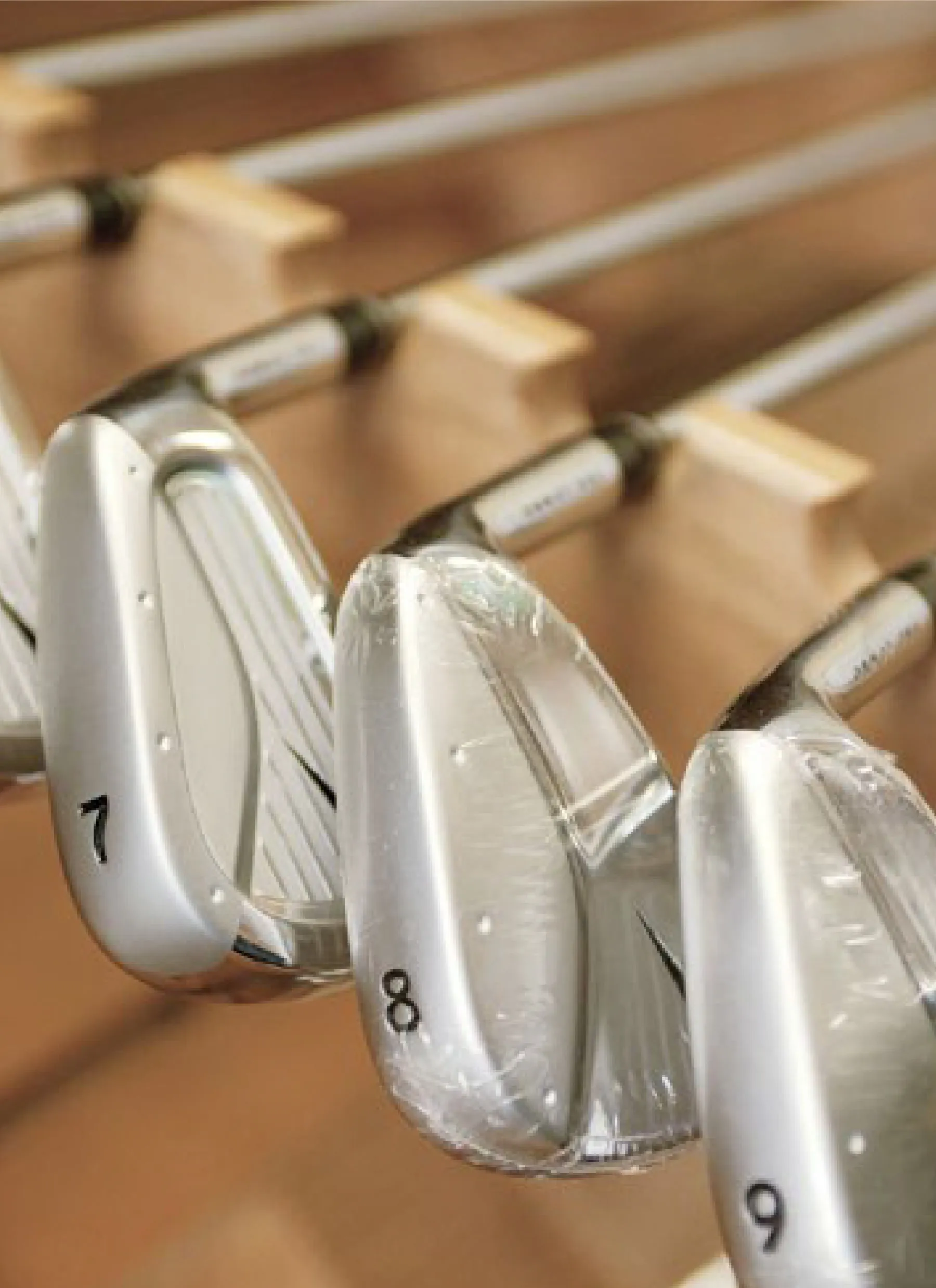Row of polished golf irons numbered 7, 8 and 9