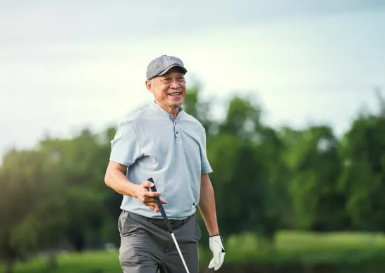 Smiling senior golfer walking the course