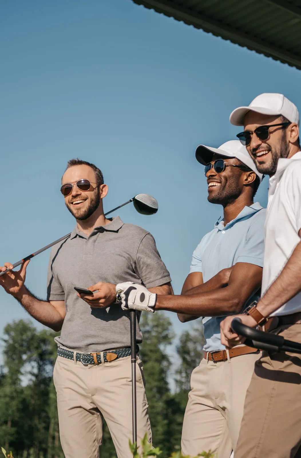 Three smiling golfers sharing a moment on the course