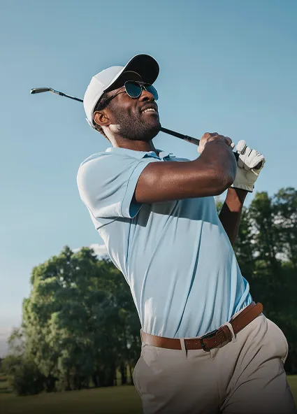 Smiling golfer finishing his swing